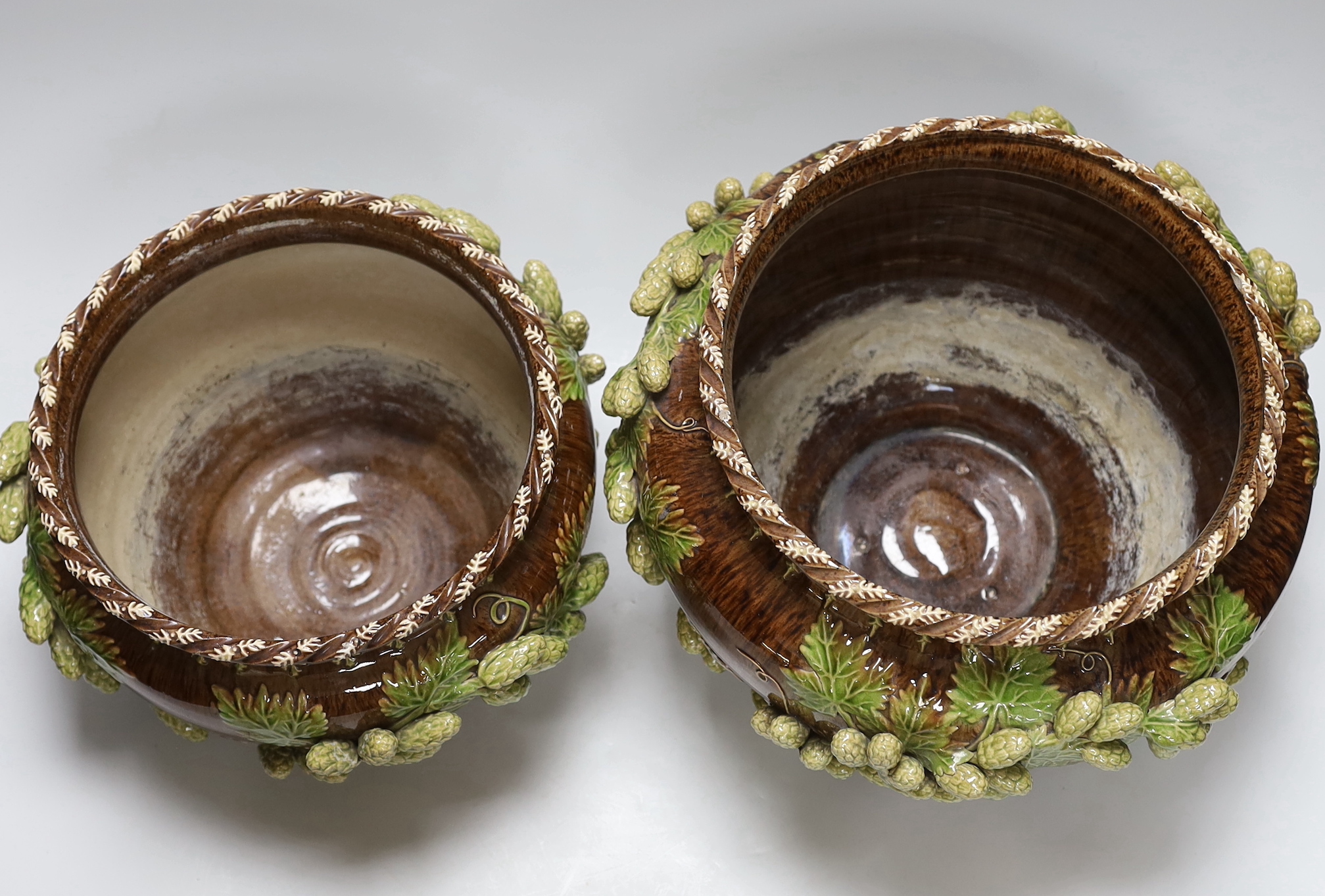 Two early 20th century Sussex Rustic Ware Rye pottery jardinières moulded with hops, each with incised marks and dated 1901 and 1903, height 21.5cm